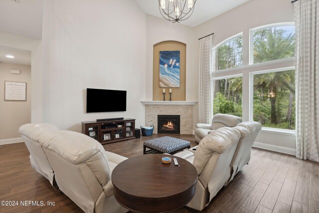 living room featuring dark hardwood / wood-style floors, an inviting chandelier, and a fireplace