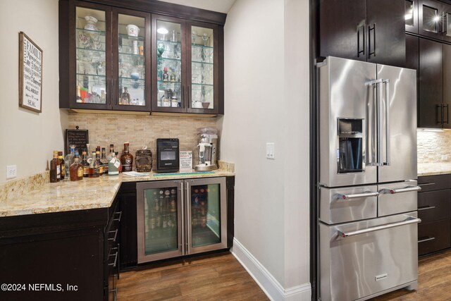 bar featuring beverage cooler, tasteful backsplash, dark wood-type flooring, and high end fridge