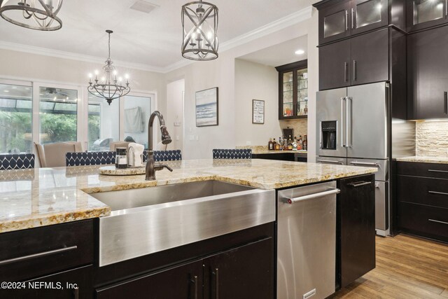 kitchen with pendant lighting, a chandelier, light hardwood / wood-style flooring, sink, and decorative backsplash