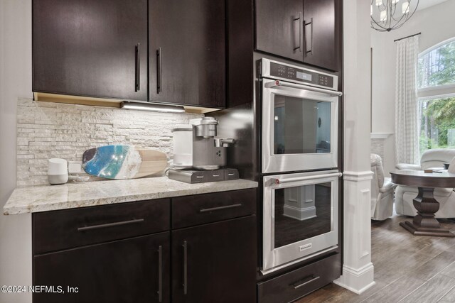 kitchen with dark brown cabinets, hardwood / wood-style floors, decorative backsplash, and double oven