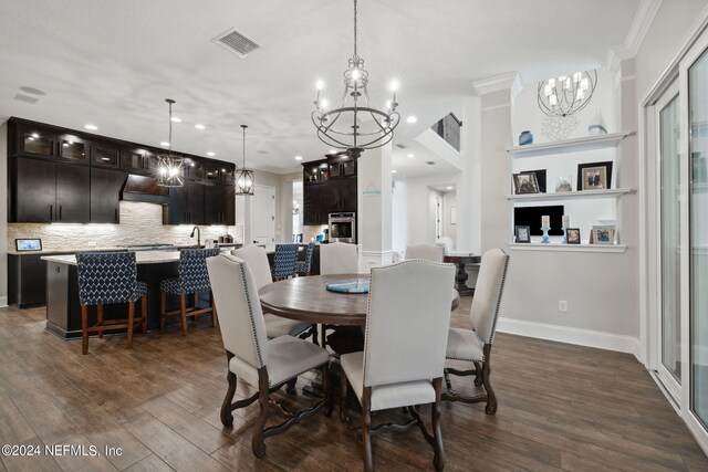 dining area with dark hardwood / wood-style floors, crown molding, and a notable chandelier