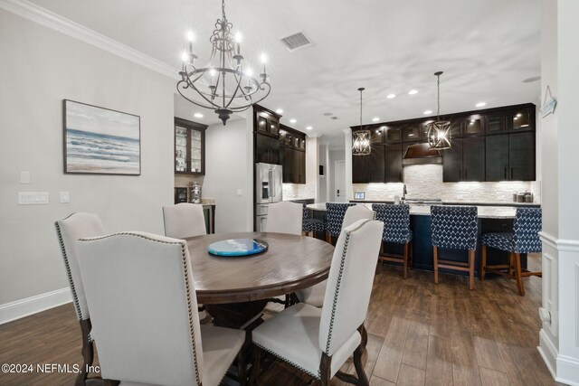 dining area featuring a chandelier, dark hardwood / wood-style flooring, and crown molding