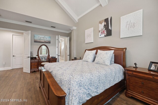 bedroom featuring dark wood-type flooring, ornamental molding, and vaulted ceiling with beams