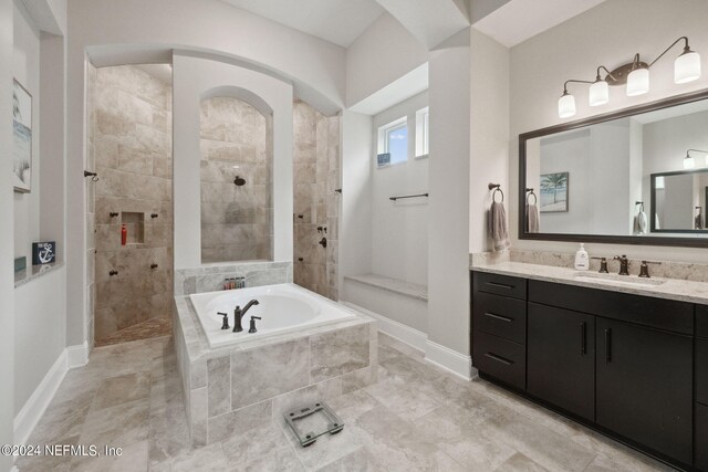 bathroom featuring vanity and independent shower and bath