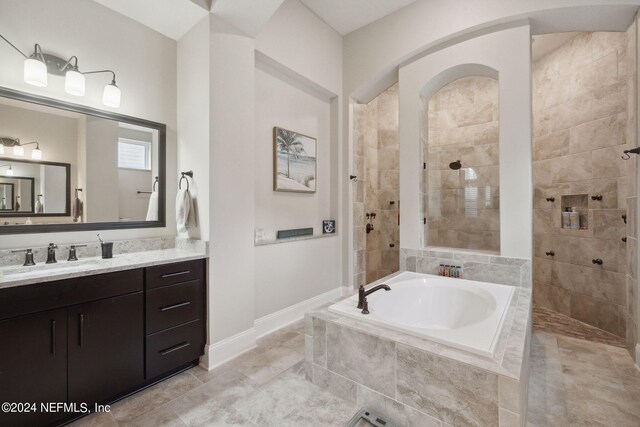 bathroom featuring vanity and independent shower and bath