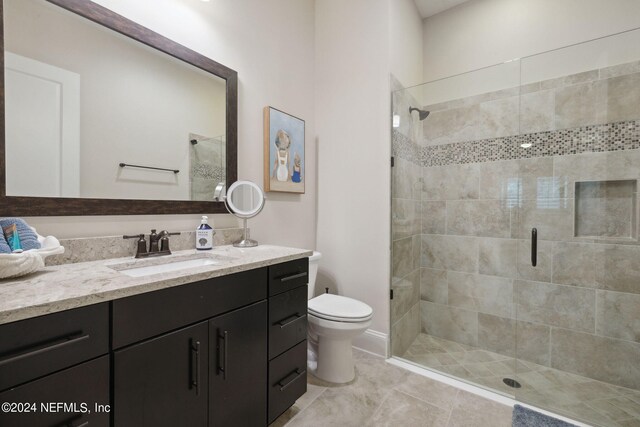 bathroom featuring vanity, toilet, and a shower with door