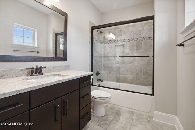 full bathroom featuring vanity, toilet, and bath / shower combo with glass door