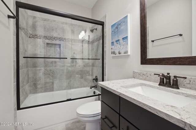 full bathroom with vanity, toilet, and enclosed tub / shower combo