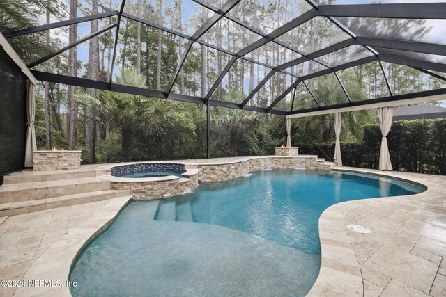 view of swimming pool with a lanai, an in ground hot tub, and a patio area