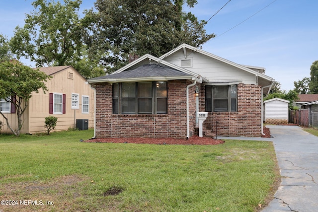 bungalow featuring cooling unit and a front lawn