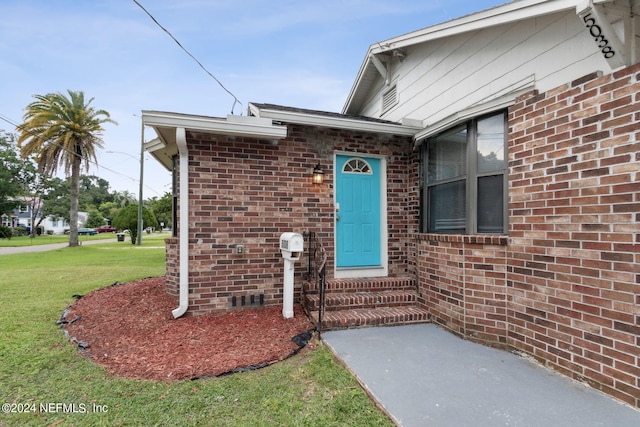 entrance to property with a lawn