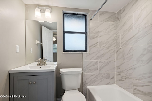 full bathroom with tiled shower / bath, vanity, and toilet