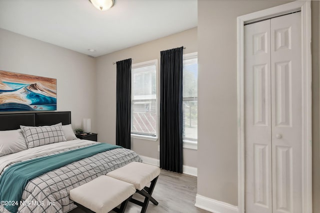 bedroom with light wood-type flooring and a closet