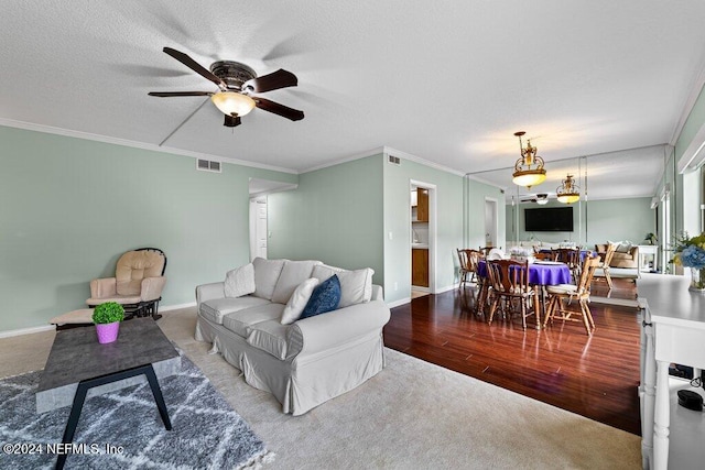 living room featuring ceiling fan, wood-type flooring, and crown molding