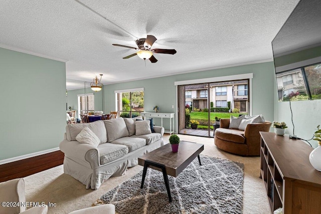 living room featuring a textured ceiling, ceiling fan, and crown molding