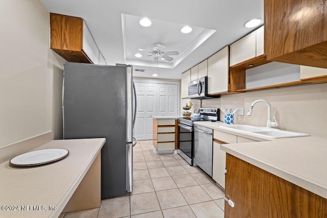 kitchen with white cabinets, a raised ceiling, sink, ceiling fan, and appliances with stainless steel finishes