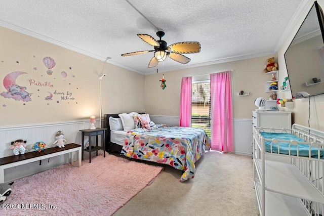 carpeted bedroom with a textured ceiling, ceiling fan, and ornamental molding