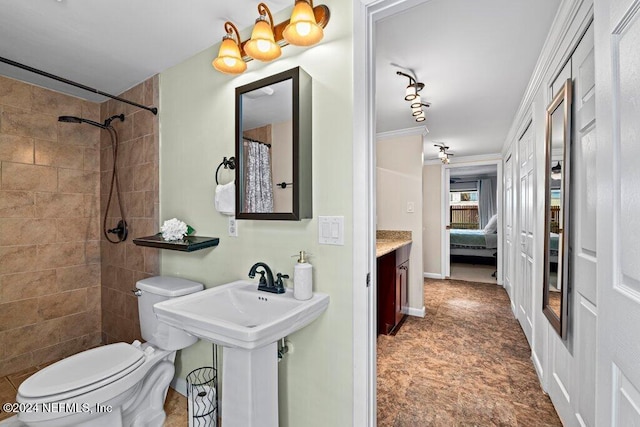 bathroom with sink, tiled shower, toilet, and crown molding