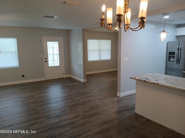 kitchen featuring dark hardwood / wood-style flooring, hanging light fixtures, an inviting chandelier, and stainless steel fridge with ice dispenser