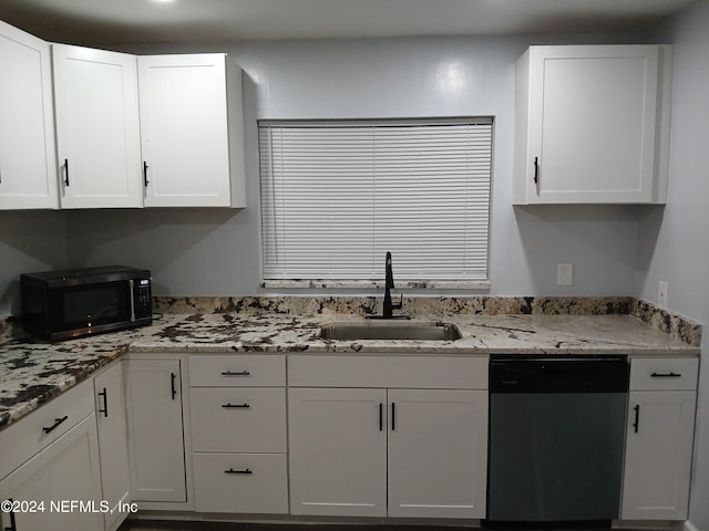 kitchen with white cabinets, appliances with stainless steel finishes, light stone counters, and sink