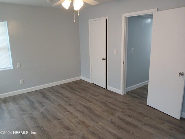 unfurnished bedroom featuring dark wood-type flooring, ceiling fan, and a closet