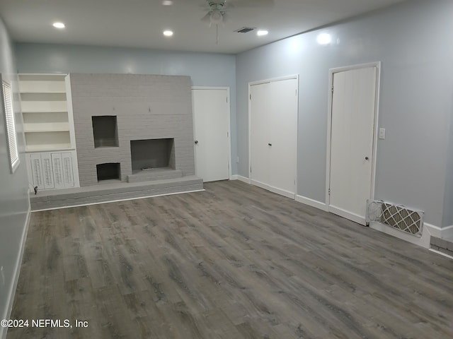 unfurnished living room with ceiling fan, hardwood / wood-style floors, and a fireplace