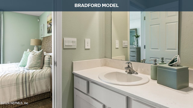 bathroom featuring a textured wall, vanity, and ensuite bathroom