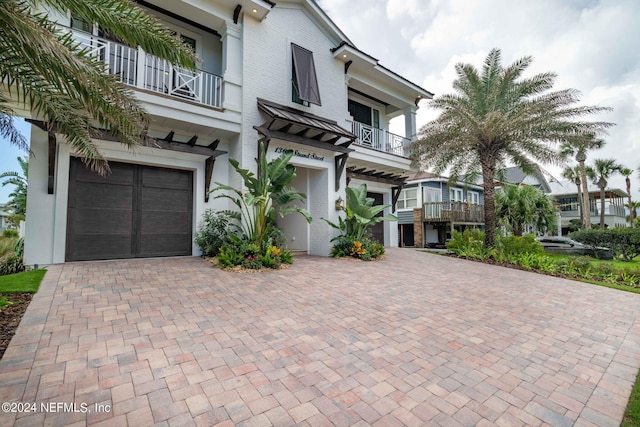 view of front of property featuring a garage and a balcony