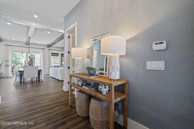 hall featuring dark wood-type flooring and beamed ceiling