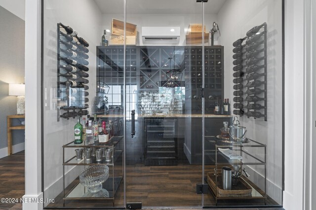 wine cellar with hardwood / wood-style floors and a wall unit AC