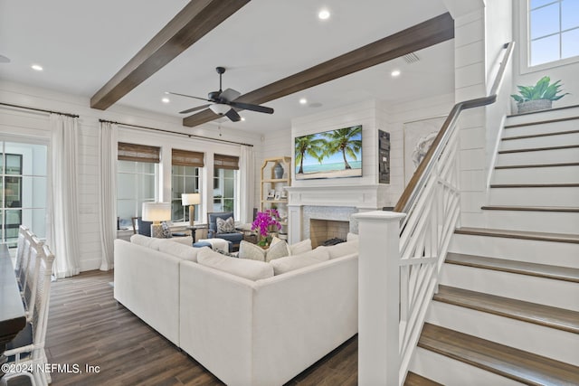 living room with a wealth of natural light, ceiling fan, a high end fireplace, and dark hardwood / wood-style floors