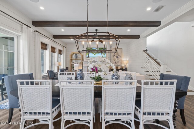 dining room with beamed ceiling, wood-type flooring, an inviting chandelier, and wood walls