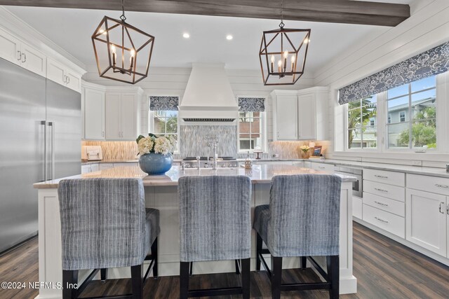 kitchen featuring a center island, custom exhaust hood, white cabinetry, and stainless steel built in fridge