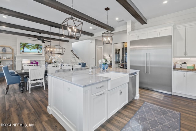 kitchen with white cabinets, decorative light fixtures, appliances with stainless steel finishes, ceiling fan with notable chandelier, and beamed ceiling