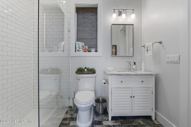 bathroom featuring vanity, toilet, and tiled shower