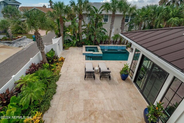 view of swimming pool featuring a patio and an in ground hot tub