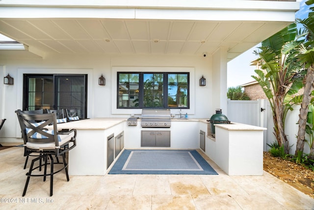 view of patio with exterior kitchen and a grill