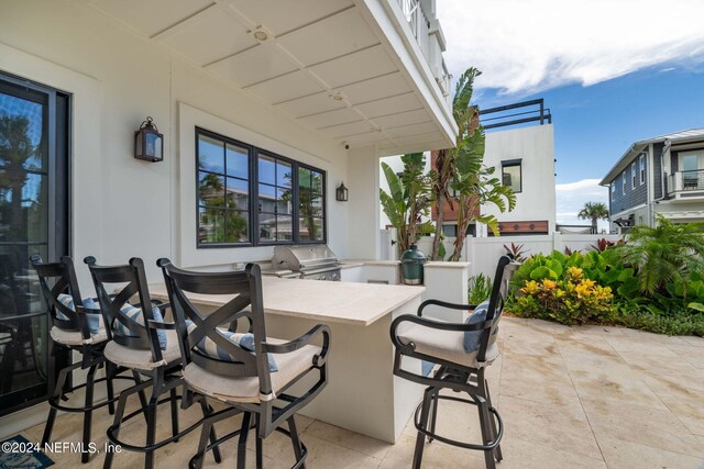 view of patio / terrace featuring exterior bar, grilling area, and an outdoor kitchen