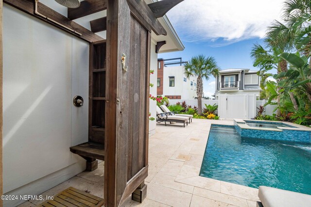 view of swimming pool featuring an in ground hot tub and a patio