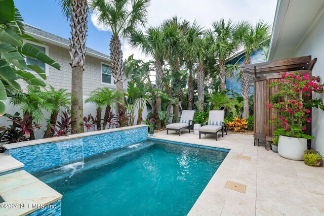 view of pool featuring pool water feature and a patio