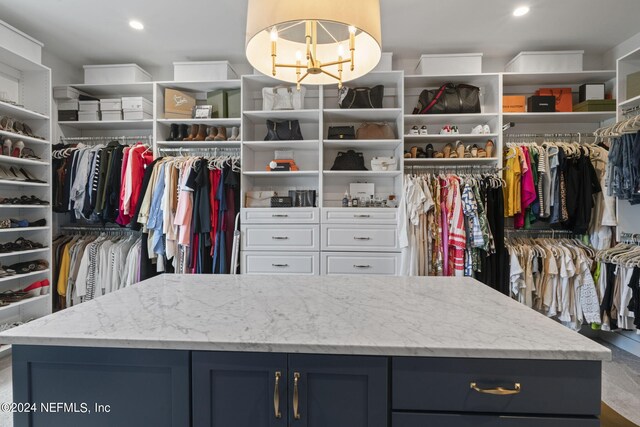 spacious closet with an inviting chandelier