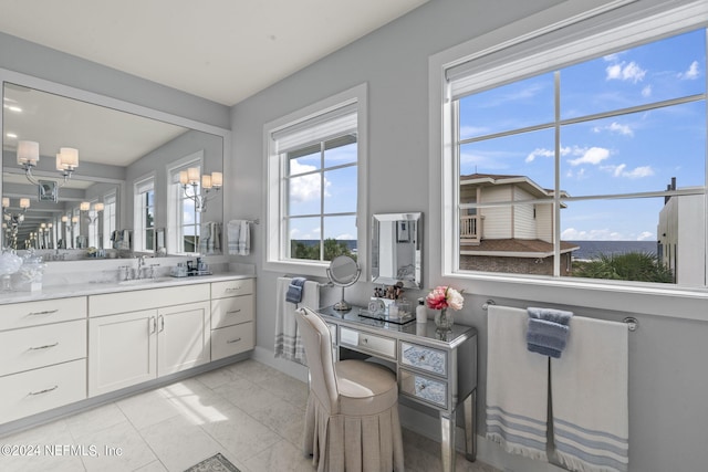 bathroom with tile patterned floors, radiator heating unit, an inviting chandelier, and vanity