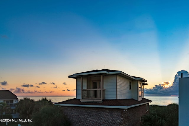 property exterior at dusk with a water view