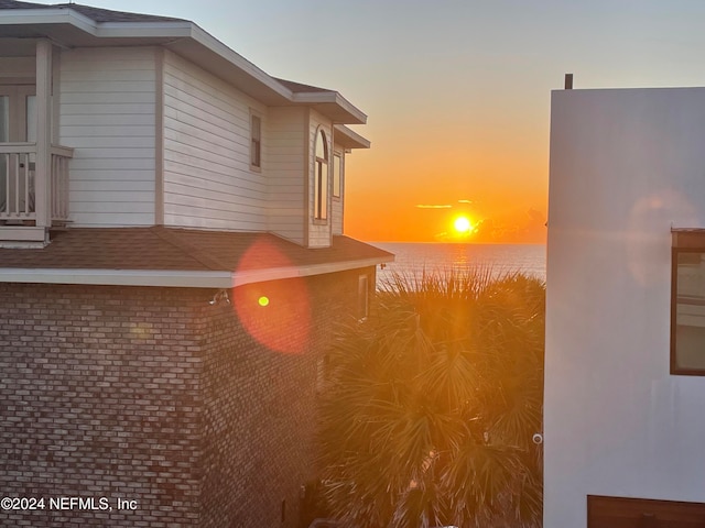 property exterior at dusk featuring a water view