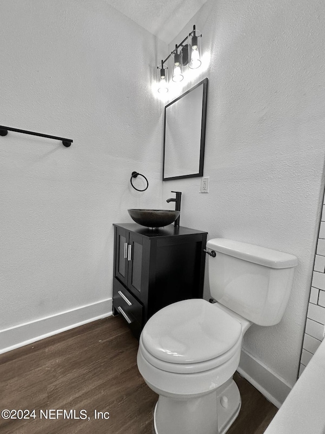 bathroom with hardwood / wood-style floors, vanity, and toilet