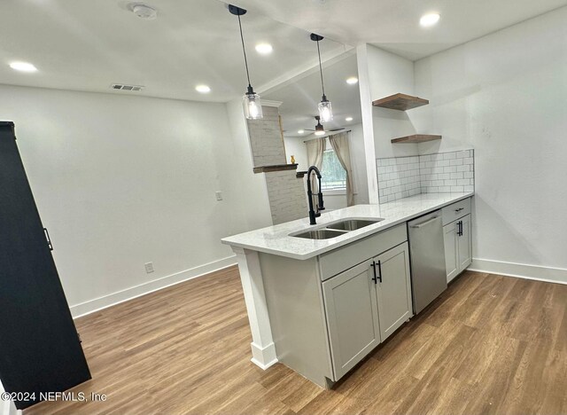 kitchen featuring kitchen peninsula, sink, stainless steel dishwasher, and light wood-type flooring