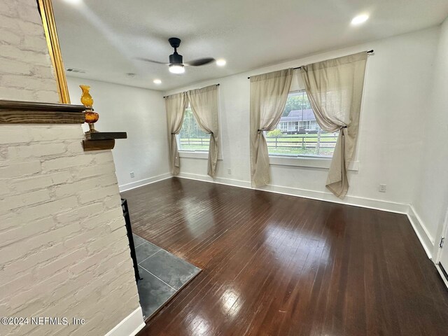 unfurnished living room with hardwood / wood-style flooring, ceiling fan, and a healthy amount of sunlight