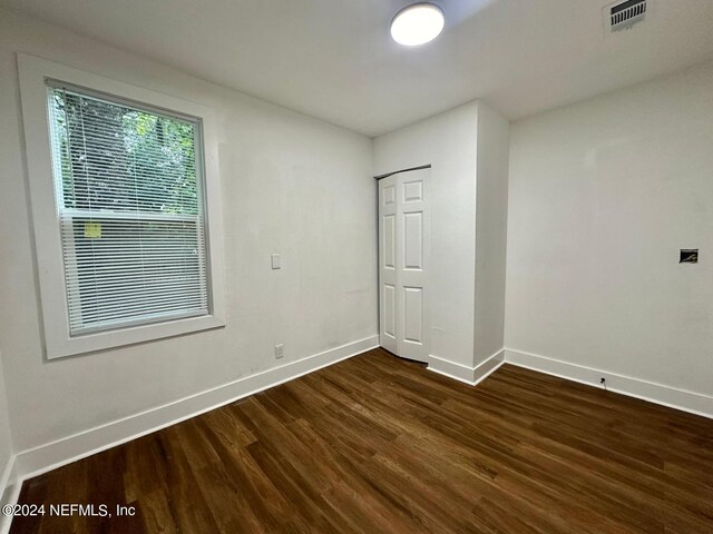 unfurnished room with dark wood-type flooring