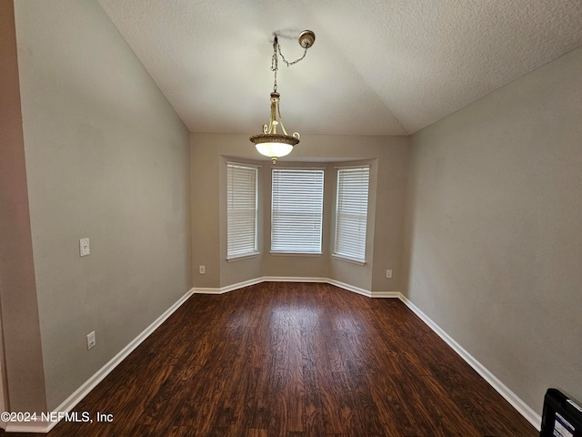 spare room featuring hardwood / wood-style floors, a textured ceiling, and lofted ceiling