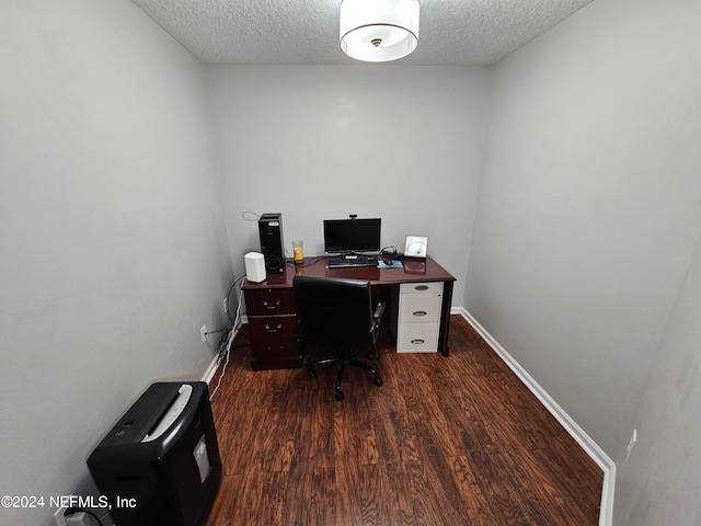 home office with a textured ceiling and dark hardwood / wood-style floors